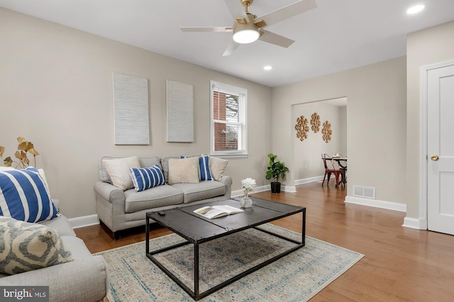 living room featuring wood-type flooring and ceiling fan