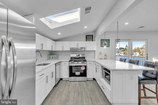 kitchen featuring appliances with stainless steel finishes, kitchen peninsula, sink, and white cabinets