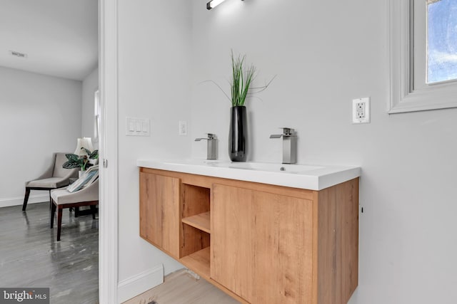 bar with sink and light hardwood / wood-style floors