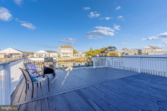 wooden deck featuring area for grilling and a water view