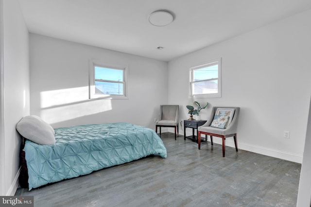 bedroom with multiple windows and wood-type flooring