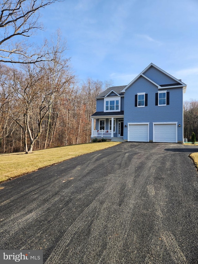 view of property with a garage, a front yard, and a porch