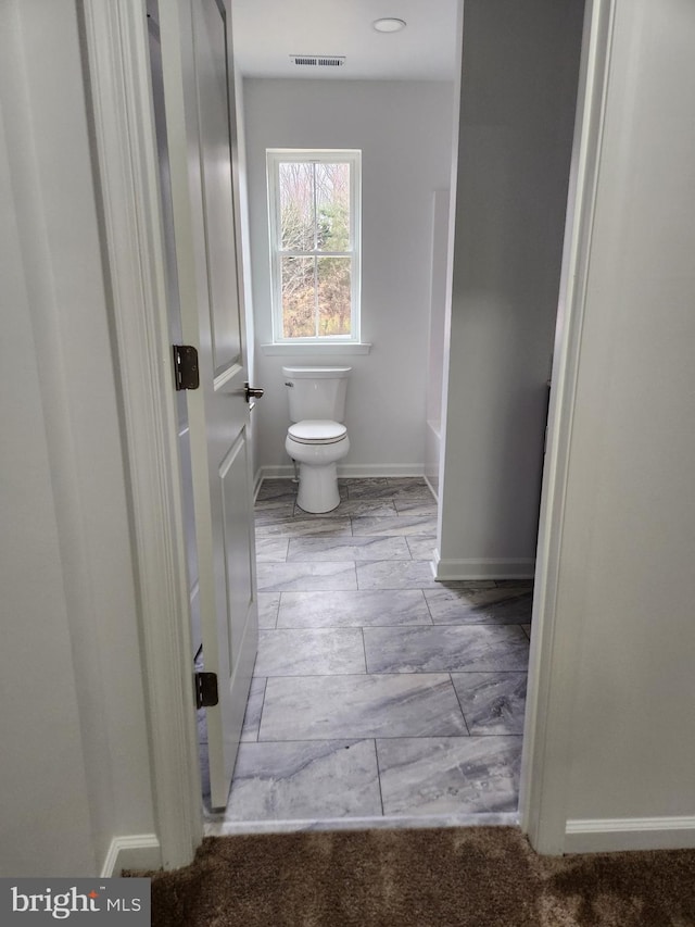 bathroom featuring a tub and toilet