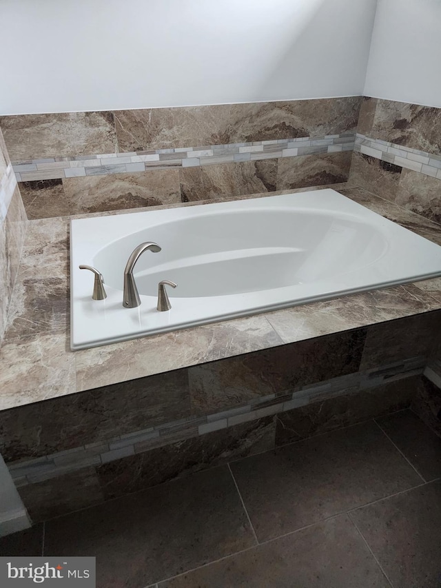 bathroom featuring a relaxing tiled tub and tile patterned floors