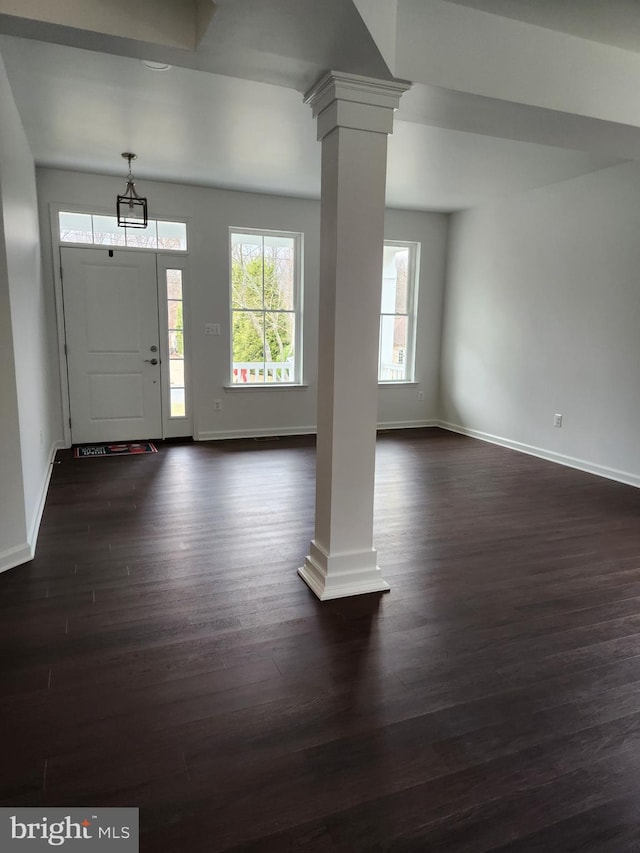 entryway with dark hardwood / wood-style floors and ornate columns