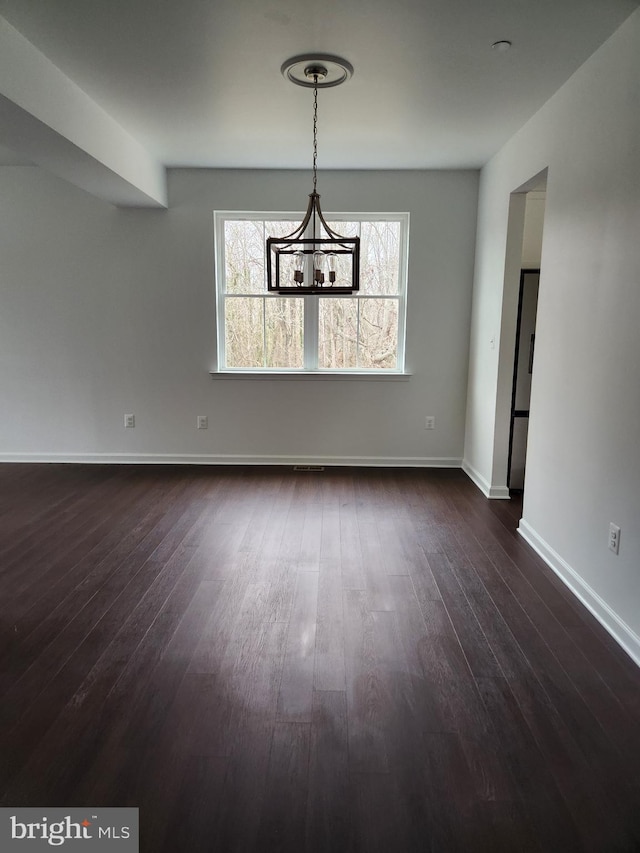 unfurnished dining area featuring dark hardwood / wood-style flooring and a notable chandelier