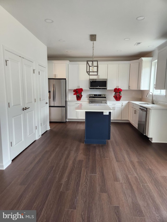 kitchen featuring pendant lighting, sink, white cabinetry, and stainless steel appliances