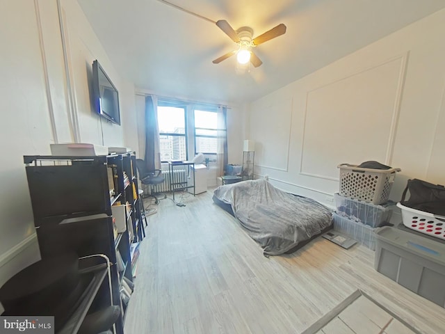 bedroom with light hardwood / wood-style flooring and ceiling fan