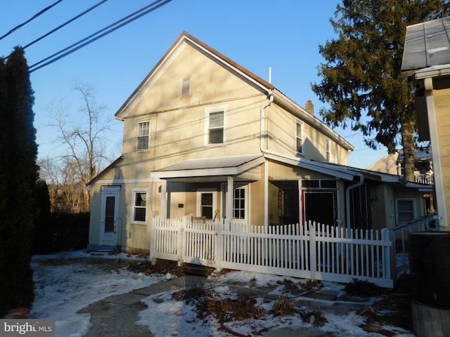 view of front facade with a fenced front yard and a chimney