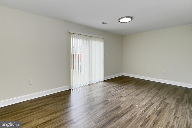 spare room with dark hardwood / wood-style floors