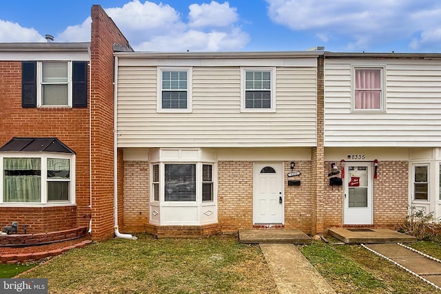 townhome / multi-family property featuring a front lawn