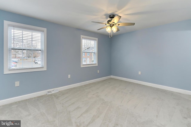 spare room featuring light carpet and ceiling fan