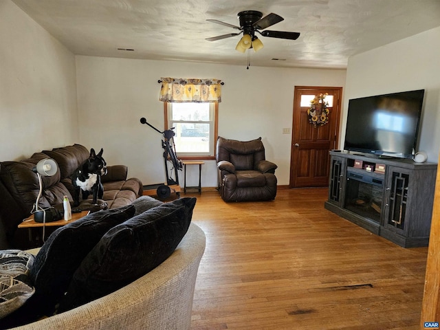 living room with ceiling fan and light hardwood / wood-style flooring