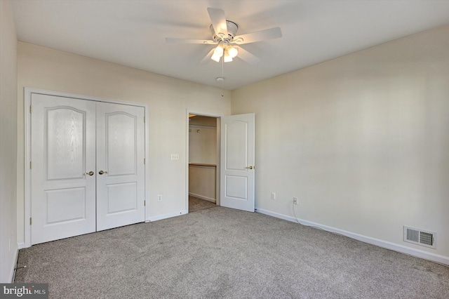 unfurnished bedroom featuring light colored carpet, ceiling fan, and a closet