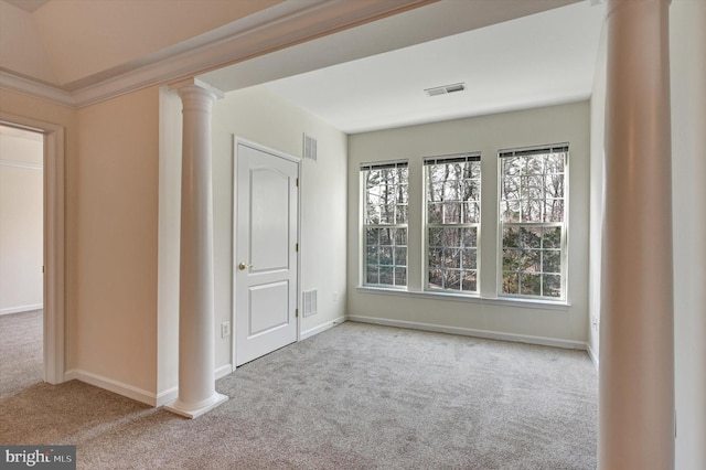 spare room with crown molding, decorative columns, and light carpet