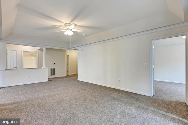 carpeted empty room featuring ceiling fan and a raised ceiling