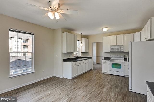 kitchen with sink, light wood-type flooring, pendant lighting, white appliances, and white cabinets