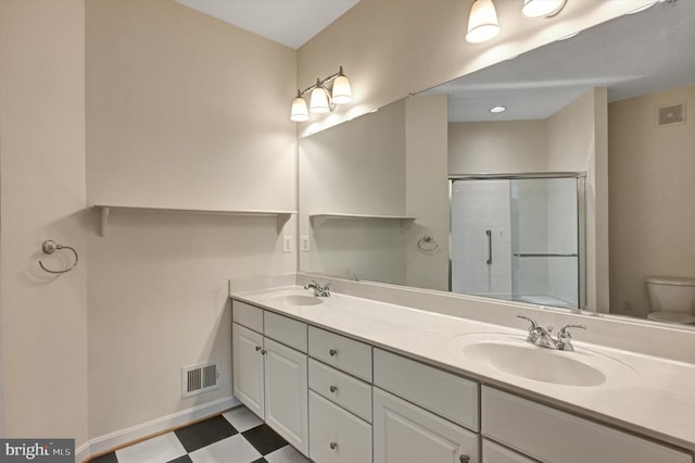 bathroom with toilet, vanity, and walk in shower