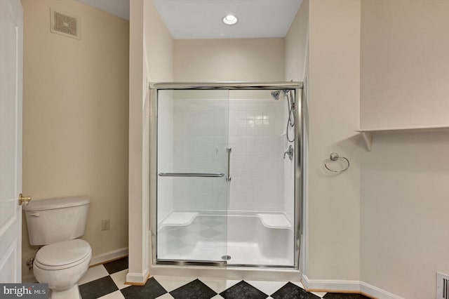 bathroom with an enclosed shower and toilet