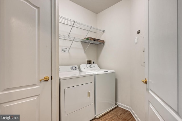 laundry area with independent washer and dryer and hardwood / wood-style floors