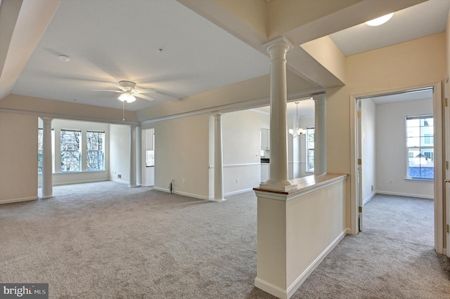 unfurnished living room with light colored carpet, decorative columns, and ceiling fan