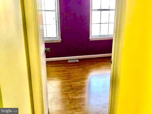 empty room with a healthy amount of sunlight and wood-type flooring