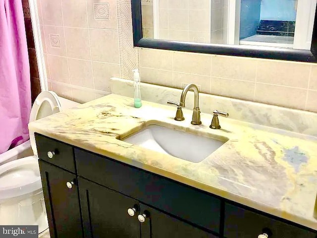 full bathroom featuring toilet, shower / tub combo, tile walls, vanity, and backsplash