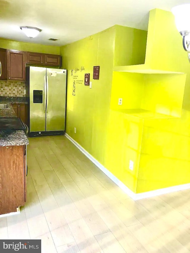 kitchen featuring stainless steel refrigerator with ice dispenser and backsplash