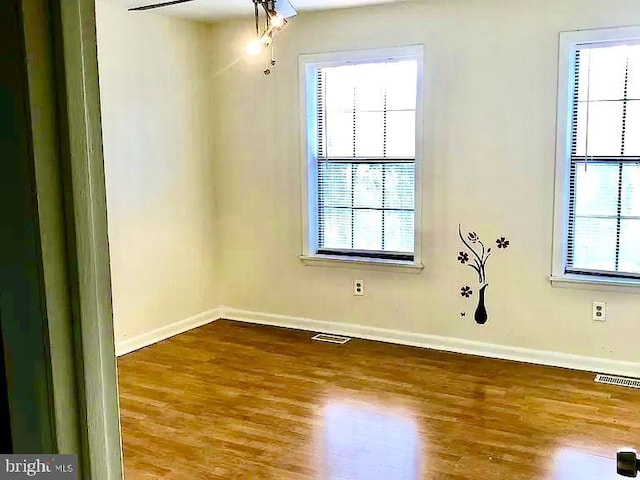 unfurnished room with wood-type flooring and a wealth of natural light