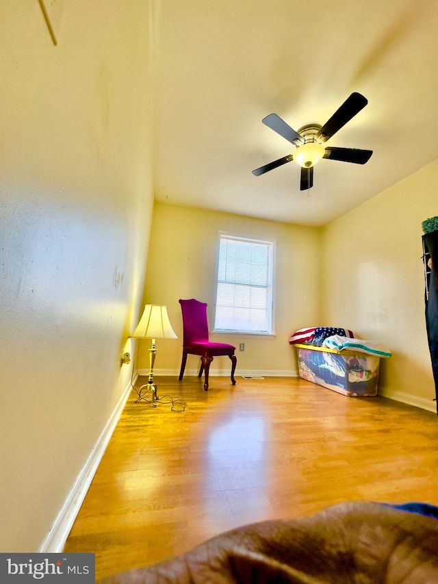 sitting room featuring wood-type flooring and ceiling fan