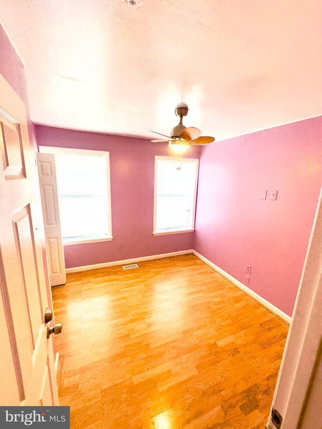 empty room featuring hardwood / wood-style floors and ceiling fan