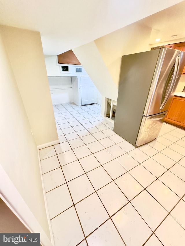 kitchen with light tile patterned floors and stainless steel refrigerator