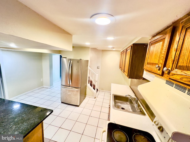 kitchen featuring sink, light tile patterned floors, and stainless steel fridge