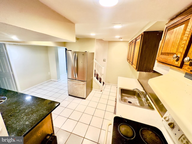 kitchen featuring sink, light tile patterned floors, and stainless steel fridge