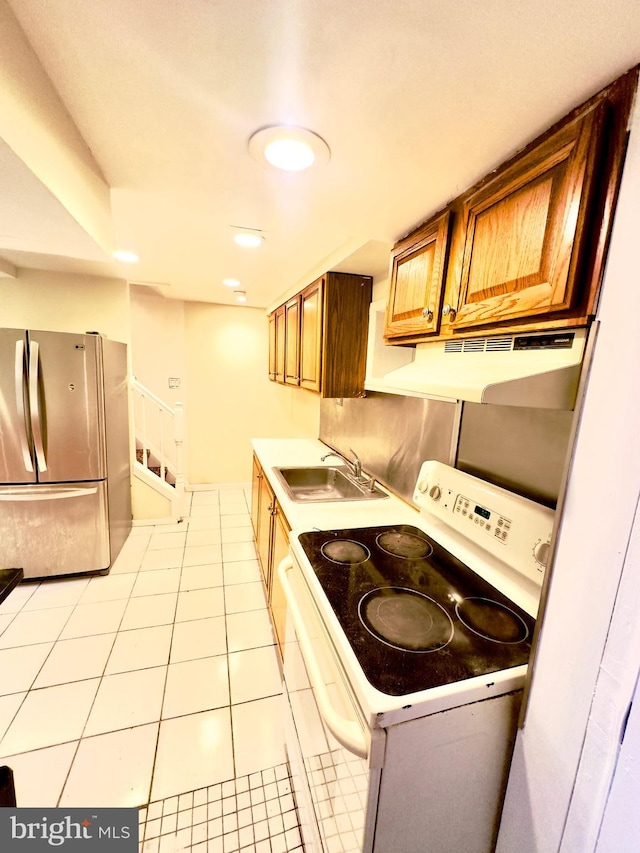 kitchen featuring electric stove, stainless steel fridge, sink, and light tile patterned floors