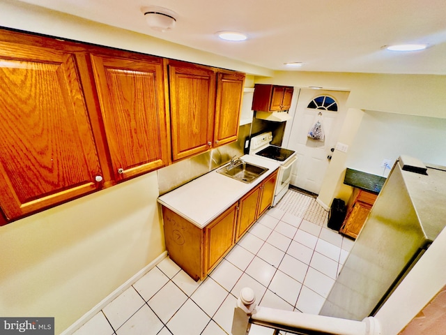 kitchen with electric stove, sink, and light tile patterned floors