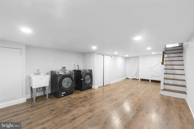 washroom featuring sink, hardwood / wood-style floors, and washing machine and clothes dryer