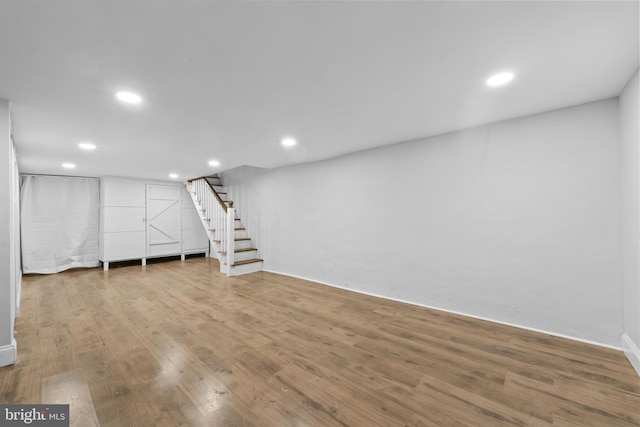 basement with hardwood / wood-style flooring