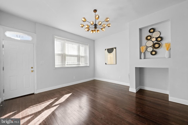 entryway with dark hardwood / wood-style floors and a notable chandelier