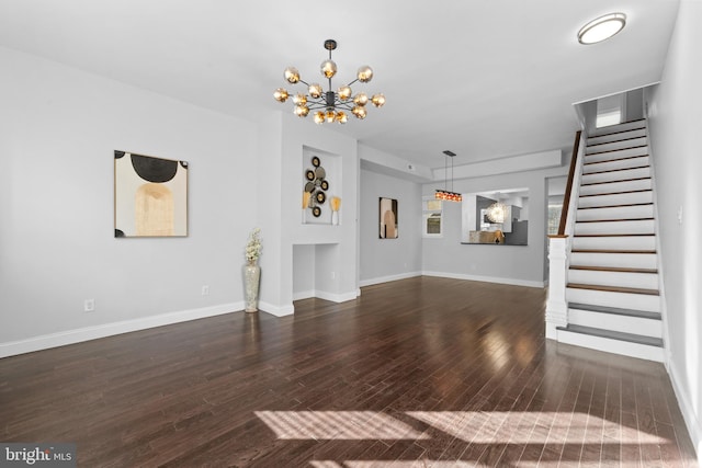 unfurnished living room featuring dark hardwood / wood-style floors and a chandelier