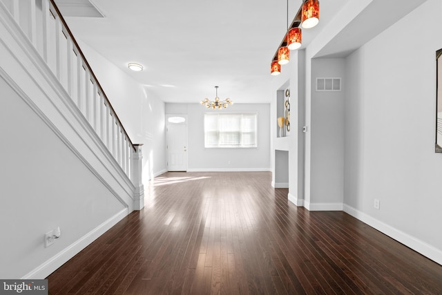 unfurnished living room featuring dark hardwood / wood-style floors and a chandelier