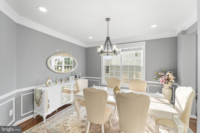 dining room with a notable chandelier, crown molding, and hardwood / wood-style floors