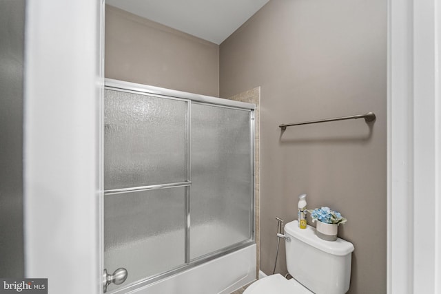 bathroom featuring enclosed tub / shower combo and toilet