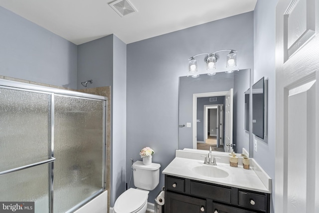 full bathroom with vanity, combined bath / shower with glass door, and toilet