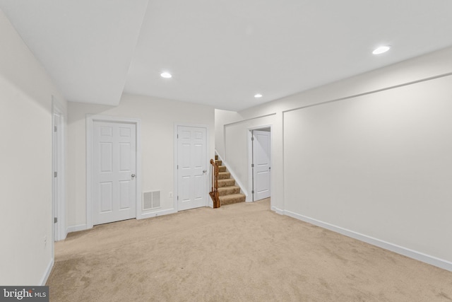 basement featuring light colored carpet