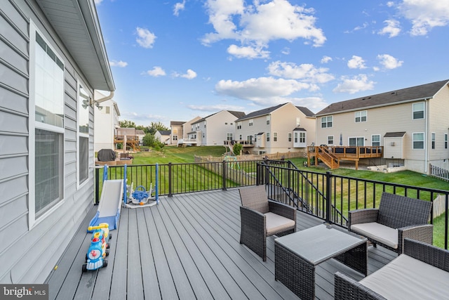 wooden terrace with an outdoor hangout area and a lawn