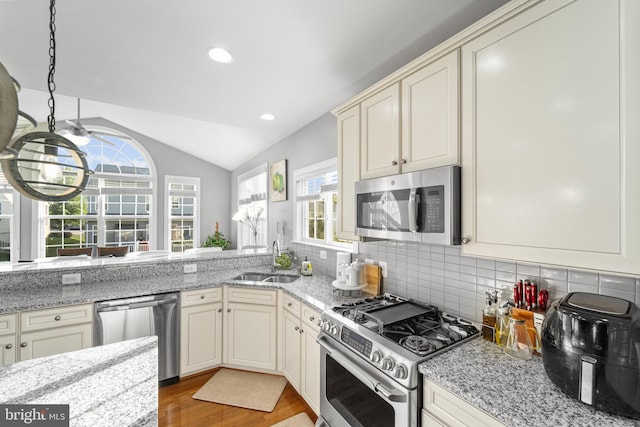 kitchen with sink, cream cabinets, and appliances with stainless steel finishes