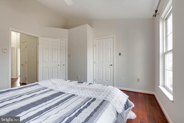 bedroom featuring dark wood-type flooring and vaulted ceiling