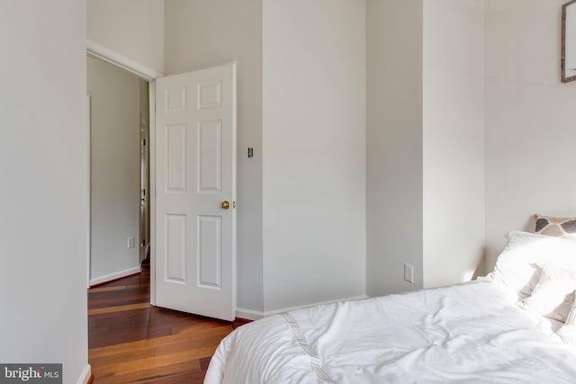 bedroom with dark hardwood / wood-style flooring