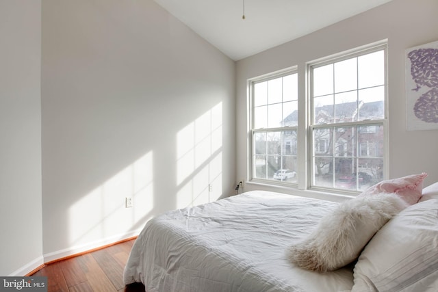 bedroom featuring lofted ceiling, hardwood / wood-style floors, and a mountain view